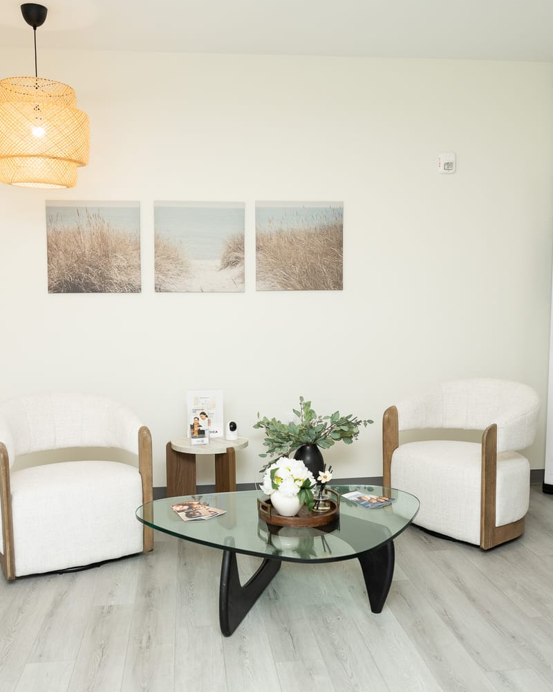 The Clinique La Roya consultation lounge with white armchairs and a glass coffee table