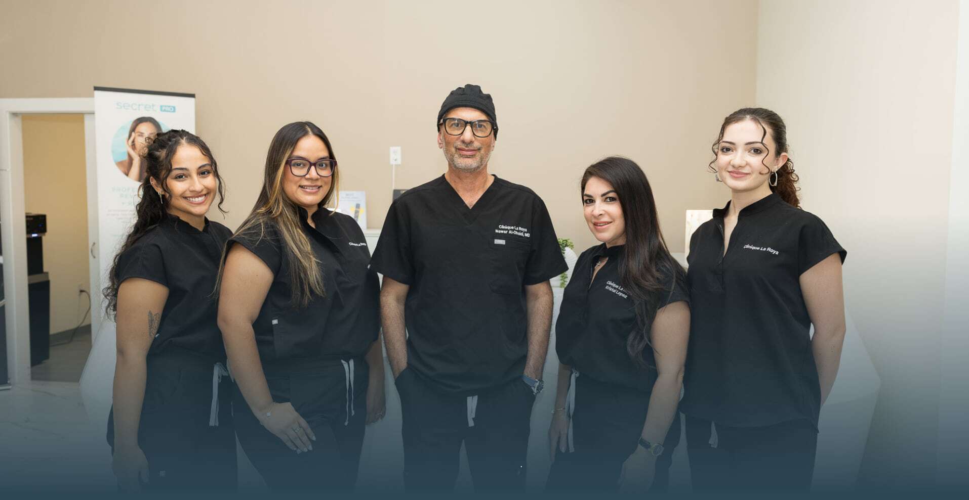 Dr. Nawar Al-Obaidi with four Clinique La Roya clinical staff in black scrubs at reception