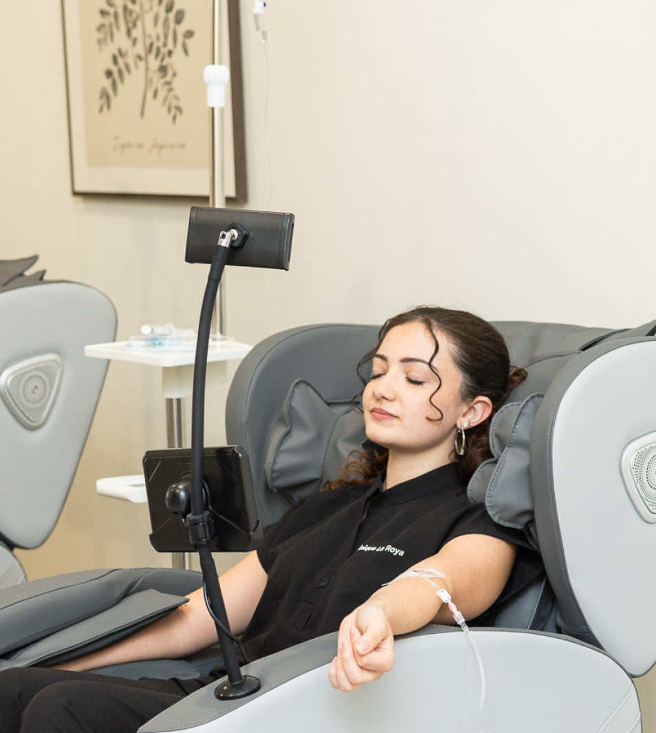 A patient seated in a treatment chair during an IV hydration session