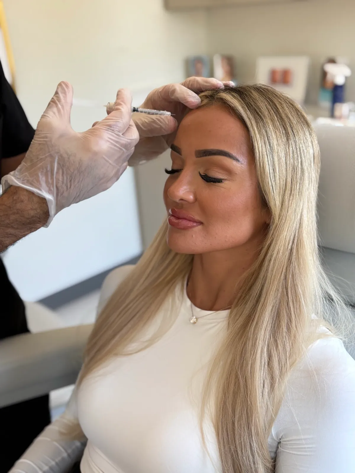 A physician giving a Botox injection to a patient’s forehead at Clinique La Roya