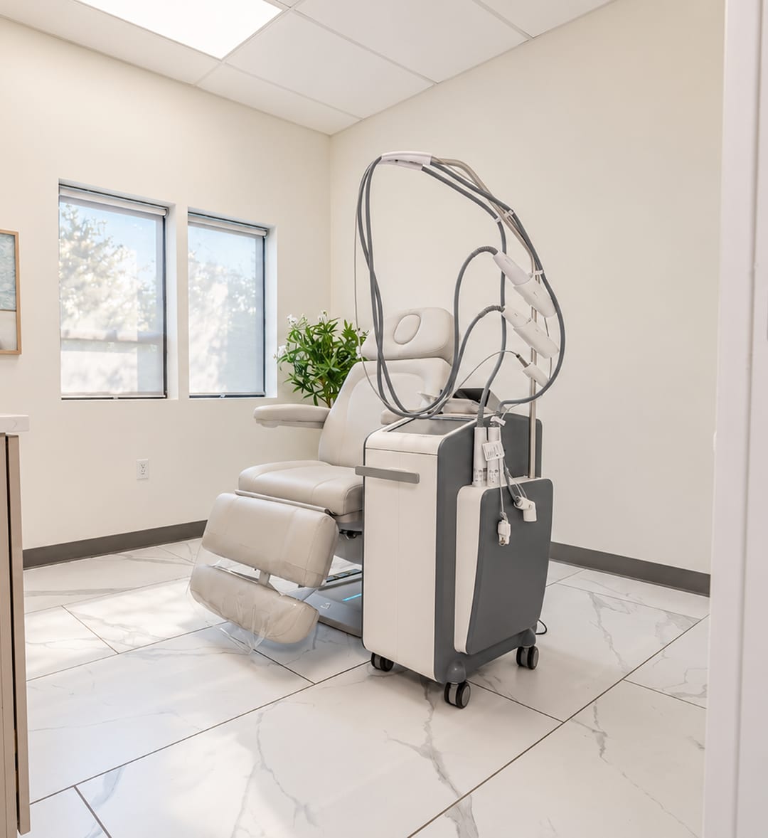 A treatment room at Clinique La Roya with a laser system beside the treatment chair
