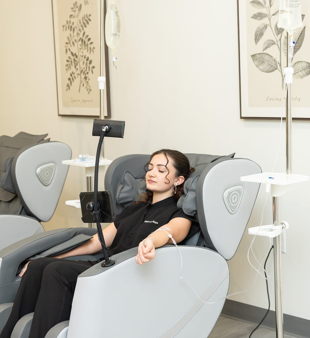 A patient relaxing in a recliner during an IV hydration session at Clinique La Roya