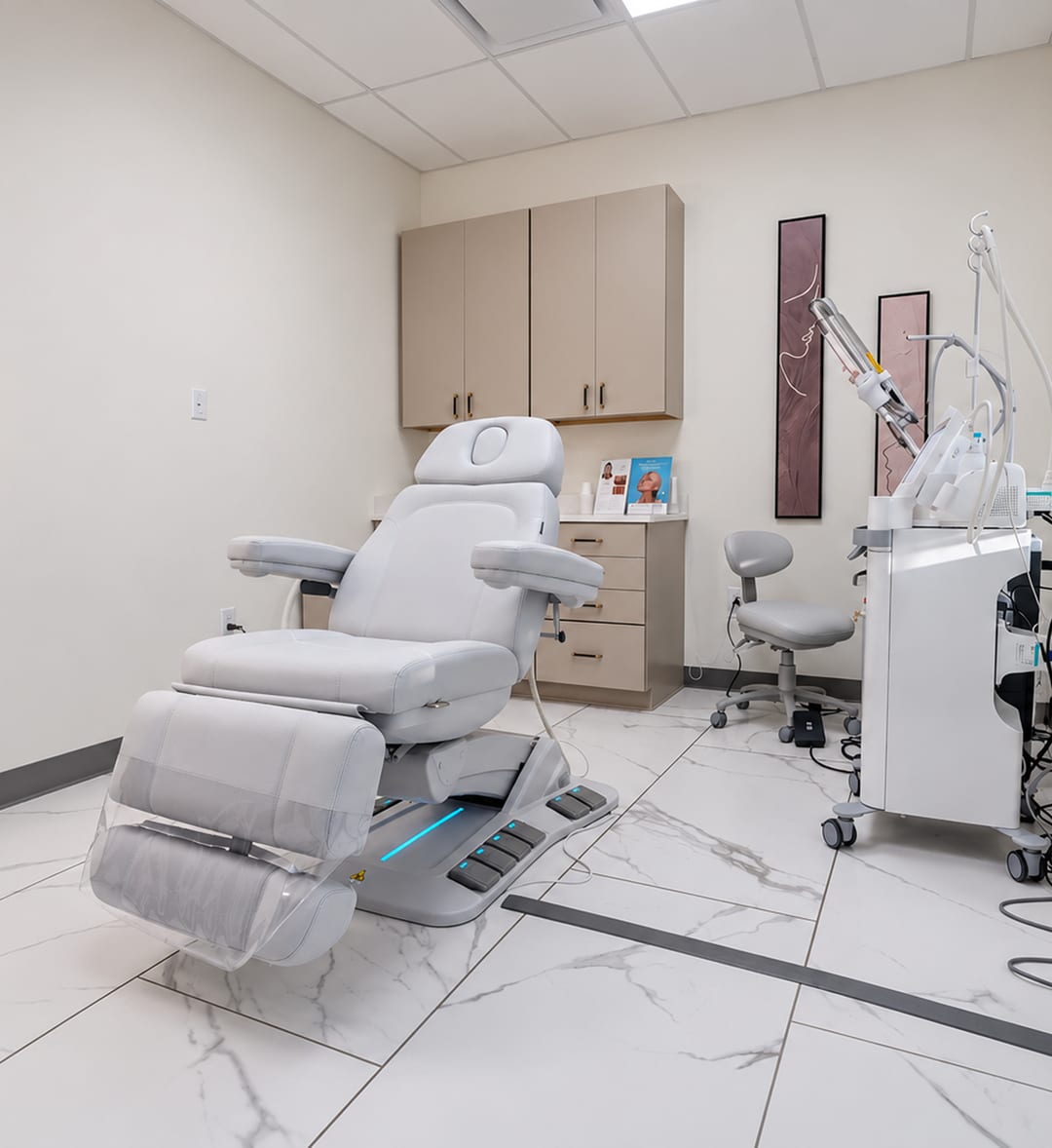 A treatment room at Clinique La Roya with a treatment chair and laser equipment